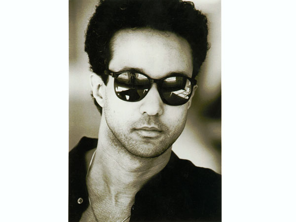 A man with sunglasses on and wearing a black shirt.